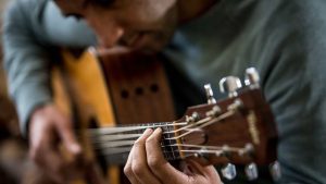 uomo distrugge una chitarra